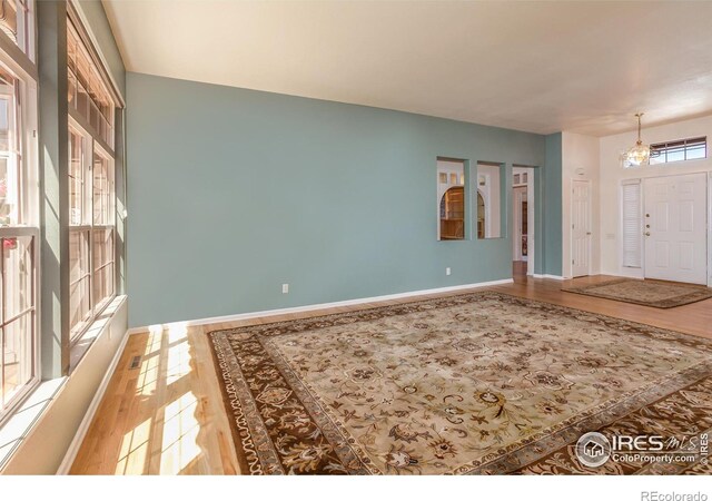 2409 Rock Creek Dr, Fort Collins, CO 80528 - entryway featuring wood finished floors, baseboards, and a chandelier
