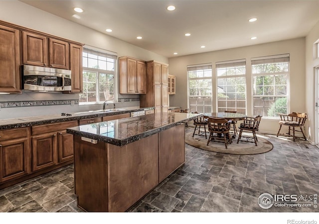 2409 Rock Creek Dr, Fort Collins, CO 80528 - kitchen with stainless steel microwave, recessed lighting, a center island, white electric stovetop, and stone finish floors