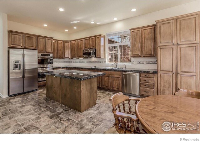 2409 Rock Creek Dr, Fort Collins, CO 80528 - kitchen featuring stainless steel appliances, a center island, recessed lighting, a sink, and dark stone counters