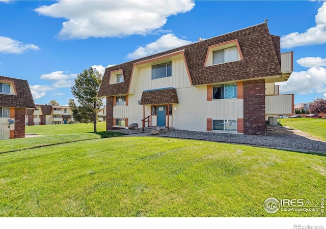 10211 Ura Ln Unit 104, Thornton, CO 80260 - back of house with a shingled roof, a lawn, and mansard roof