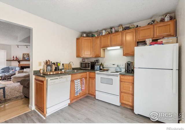 2315 Spruce St, Boulder, CO 80302 - kitchen with white appliances, a sink, light wood-type flooring, a textured ceiling, and dark countertops