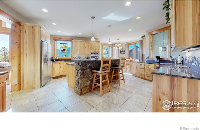 1049 Pine Knoll Dr, Estes Park, CO 80517 - kitchen featuring light brown cabinetry, stainless steel appliances, a kitchen bar, recessed lighting, and light tile patterned floors