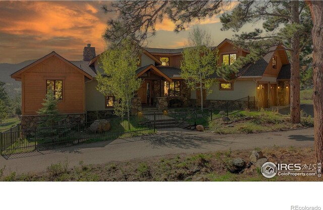 1049 Pine Knoll Dr, Estes Park, CO 80517 - view of front of property featuring stone siding, a fenced front yard, and a chimney