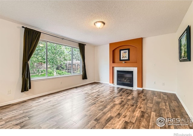 1842 Reliance Cir, Superior, CO 80027 - unfurnished living room featuring a textured ceiling, wood finished floors, a fireplace, and baseboards