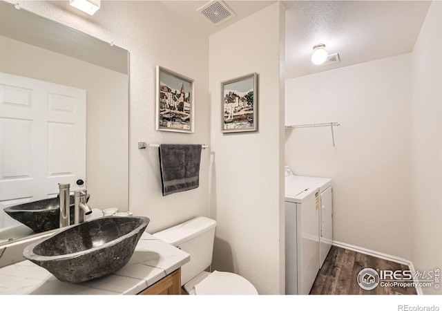 1842 Reliance Cir, Superior, CO 80027 - half bathroom with separate washer and dryer, vanity, toilet, and wood finished floors