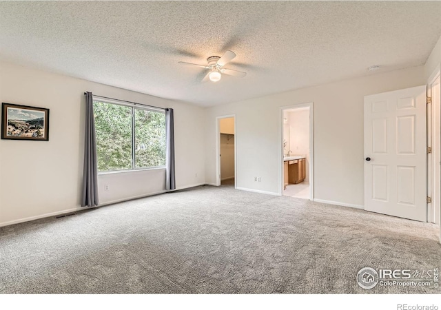 1842 Reliance Cir, Superior, CO 80027 - unfurnished bedroom featuring carpet flooring, a walk in closet, a textured ceiling, baseboards, and ensuite bath