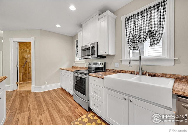 kitchen with stainless steel appliances, white cabinetry, light wood-style floors, recessed lighting, and baseboards