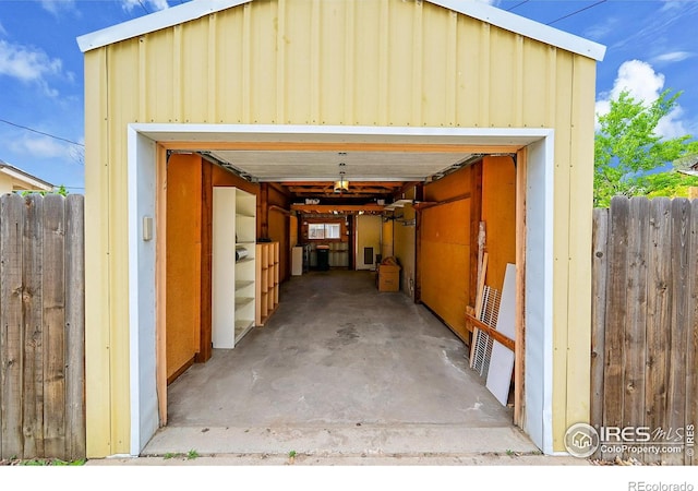 view of car parking with fence and a garage