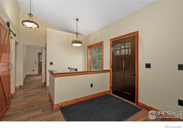 200 Falls Creek Dr, Bellvue, CO 80512 - entrance foyer with a barn door, dark wood-style flooring, baseboards, a chandelier, and vaulted ceiling