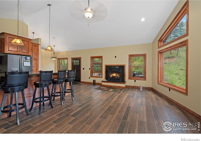 200 Falls Creek Dr, Bellvue, CO 80512 - living room featuring high vaulted ceiling, dark wood-type flooring, baseboards, a ceiling fan, and a lit fireplace