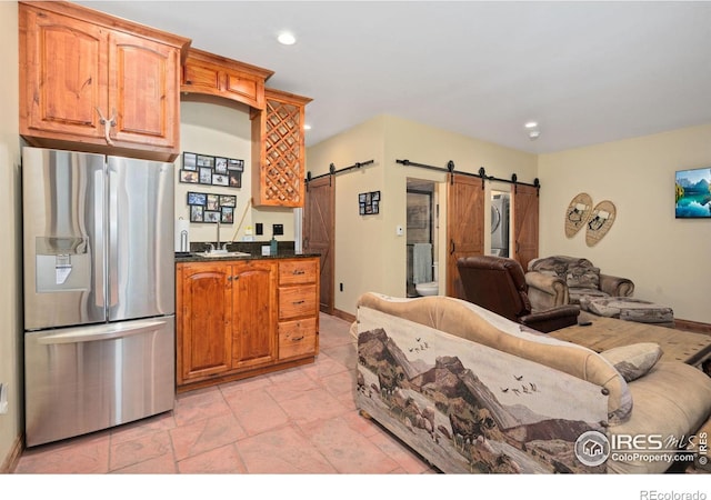 200 Falls Creek Dr, Bellvue, CO 80512 - kitchen featuring stainless steel refrigerator with ice dispenser, a barn door, stacked washing machine and dryer, open floor plan, and recessed lighting