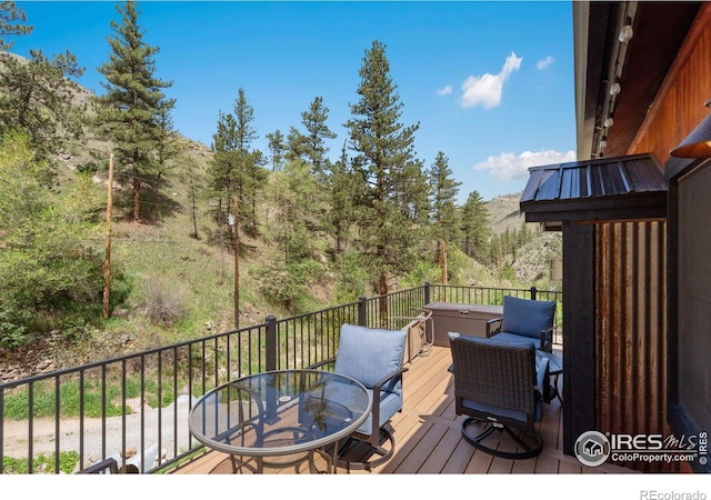 200 Falls Creek Dr, Bellvue, CO 80512 - wooden terrace with outdoor dining space and a wooded view