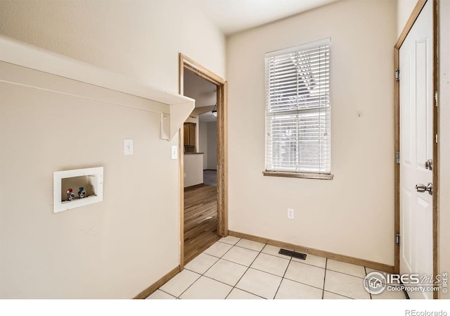 laundry room with washer hookup, baseboards, and light tile patterned floors