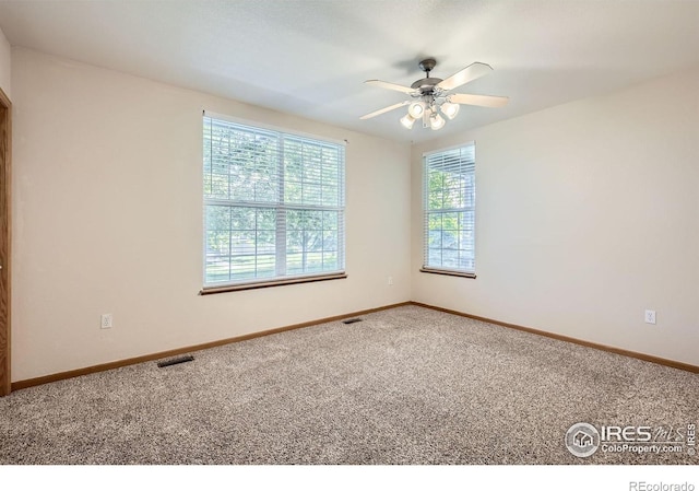 spare room with carpet floors, ceiling fan, and baseboards