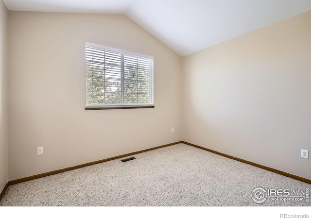 unfurnished room featuring carpet, lofted ceiling, and baseboards