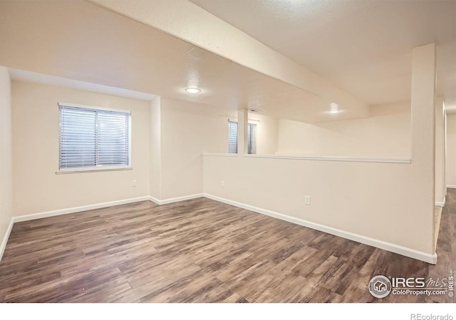 spare room with wood finished floors, baseboards, and healthy amount of natural light