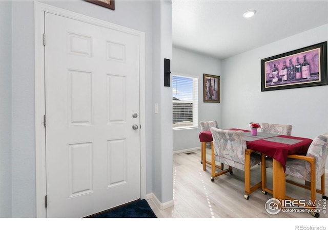 dining room with baseboards, light wood-style flooring, and recessed lighting