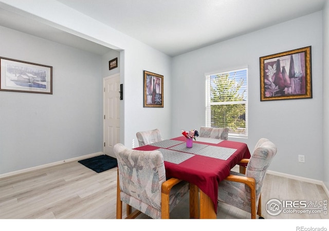dining area featuring light wood-type flooring and baseboards