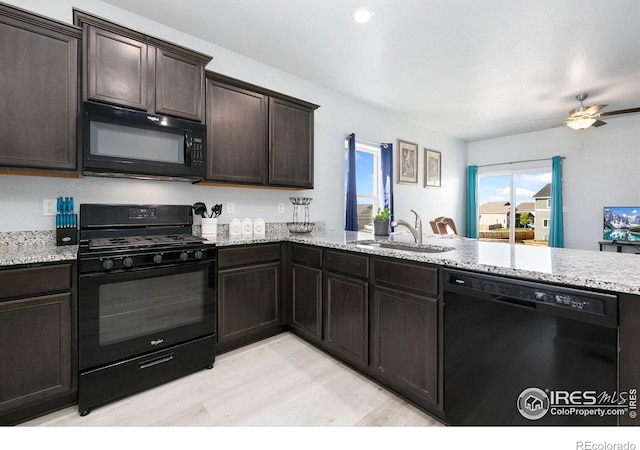 kitchen featuring black appliances, a sink, a peninsula, ceiling fan, and dark brown cabinetry