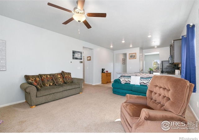 living area featuring light colored carpet, ceiling fan, recessed lighting, and baseboards