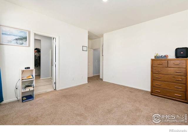 bedroom with carpet, baseboards, and a spacious closet