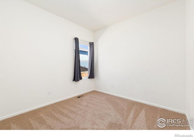 carpeted empty room with baseboards