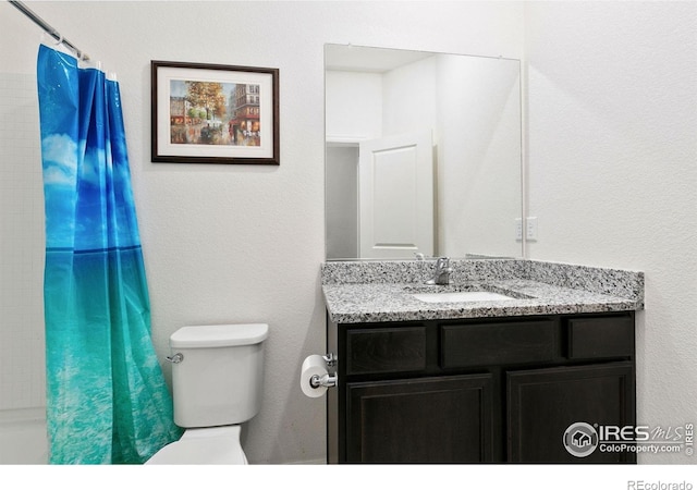 bathroom featuring toilet, vanity, and a shower with shower curtain