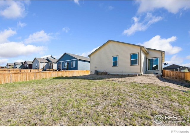 back of property with a residential view and central AC unit