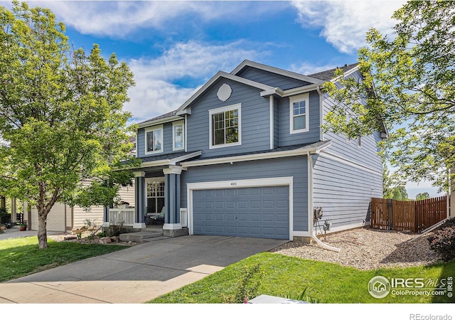 traditional home with a garage, fence, and driveway