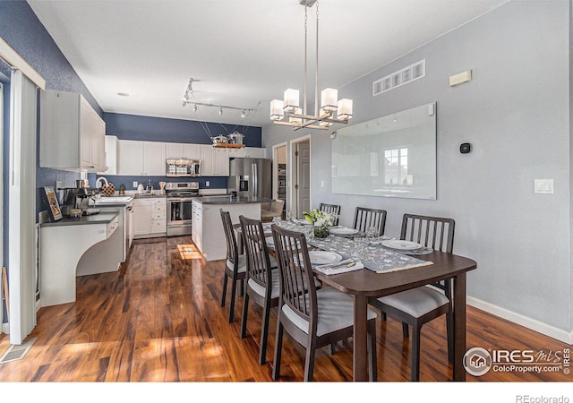 dining room featuring a chandelier, dark wood-type flooring, and baseboards