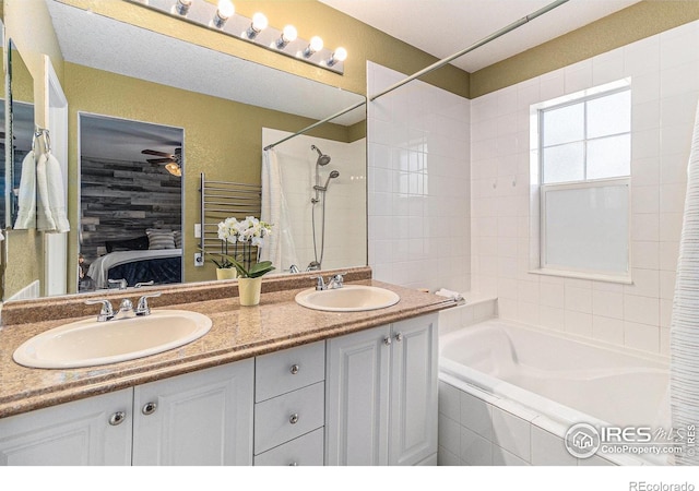 ensuite bathroom featuring double vanity and ceiling fan