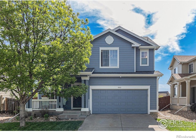 view of front of home featuring driveway, a garage, and fence