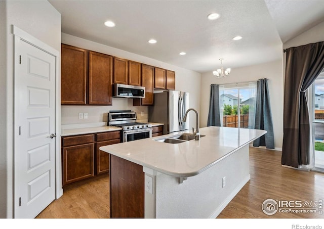 1468 Moraine Valley Dr, Severance, CO 80550 - kitchen with stainless steel appliances, a sink, light wood-style flooring, a chandelier, and recessed lighting
