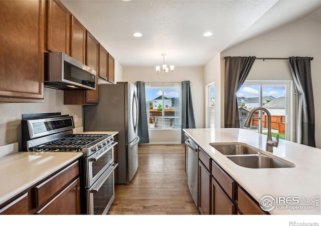 1468 Moraine Valley Dr, Severance, CO 80550 - kitchen featuring appliances with stainless steel finishes, a sink, wood finished floors, recessed lighting, and light countertops