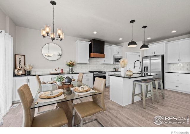 dining room featuring a chandelier, light wood-style flooring, and recessed lighting