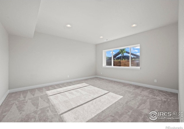 spare room featuring carpet, baseboards, and recessed lighting