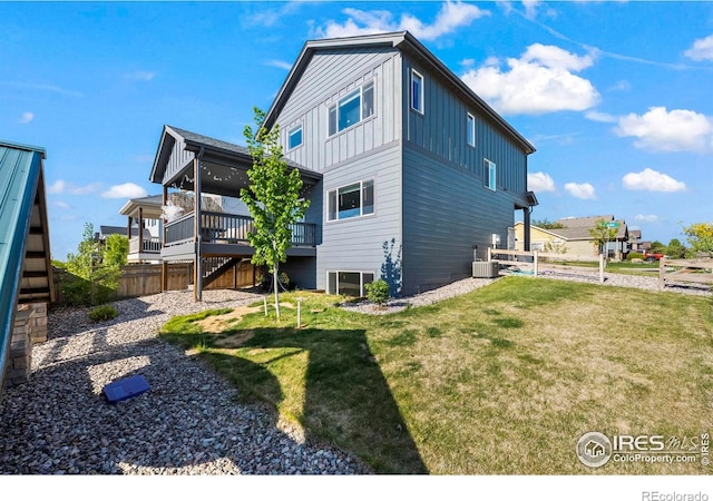 back of house featuring board and batten siding, stairs, and a wooden deck