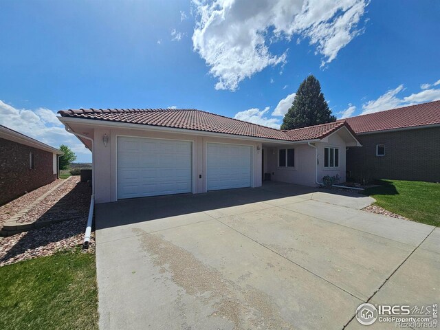 107 Fairway Ln, Fort Morgan, CO 80701 - ranch-style home featuring a tiled roof, a garage, concrete driveway, and stucco siding
