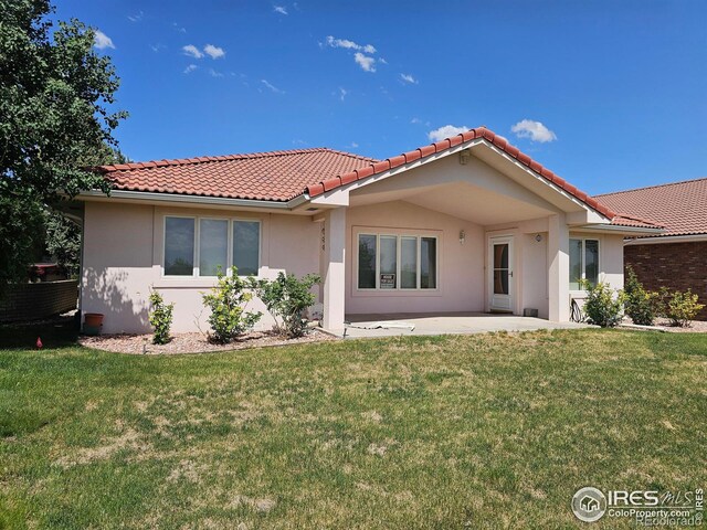 107 Fairway Ln, Fort Morgan, CO 80701 - view of front of home with stucco siding, a tiled roof, a patio, and a front yard