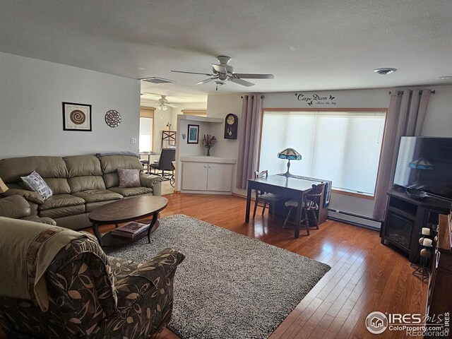 107 Fairway Ln, Fort Morgan, CO 80701 - living area featuring a baseboard radiator, ceiling fan, and wood-type flooring