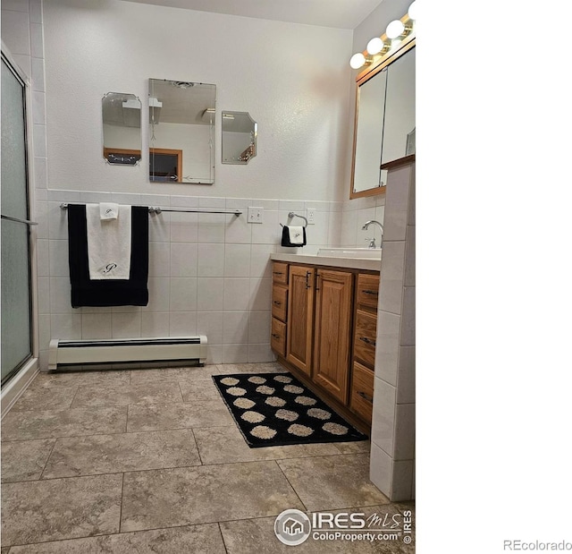 107 Fairway Ln, Fort Morgan, CO 80701 - full bath with baseboard heating, tile walls, a shower with shower door, and vanity
