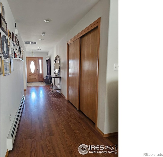 107 Fairway Ln, Fort Morgan, CO 80701 - hallway featuring a baseboard heating unit, dark wood finished floors, and baseboards