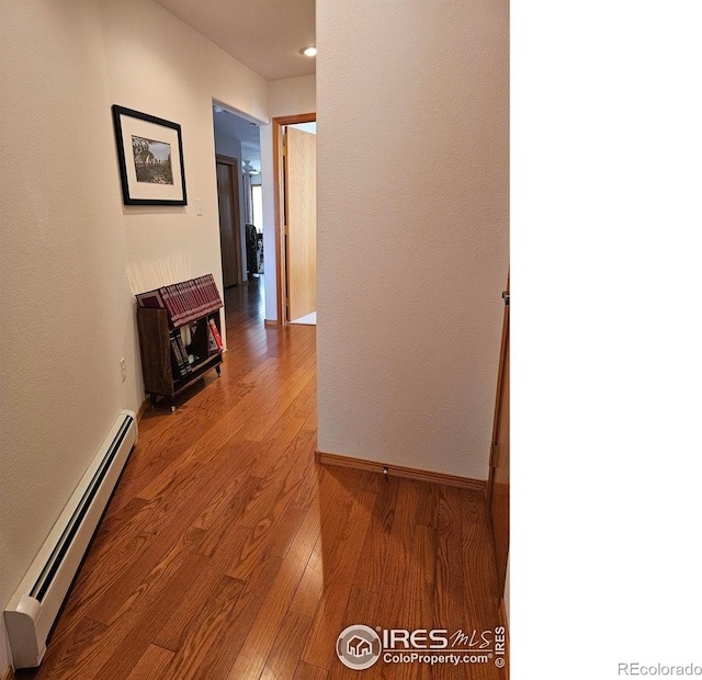 107 Fairway Ln, Fort Morgan, CO 80701 - hallway with a baseboard heating unit, wood finished floors, and baseboards