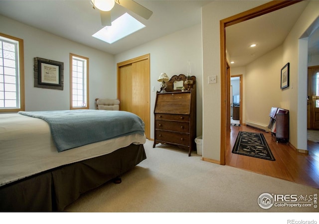 107 Fairway Ln, Fort Morgan, CO 80701 - bedroom with baseboard heating, a skylight, a closet, ceiling fan, and recessed lighting
