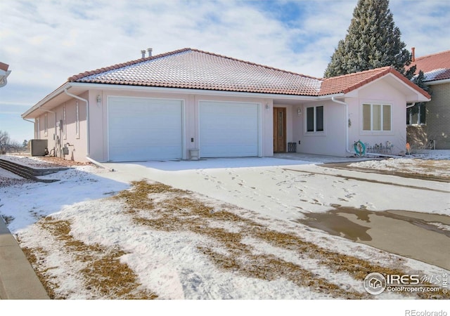 107 Fairway Ln, Fort Morgan, CO 80701 - view of front facade featuring a tiled roof, a garage, and stucco siding
