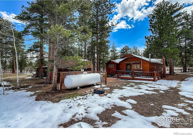 6 Norske Trl, Allenspark, CO 80510 - view of snowy exterior featuring a deck, log veneer siding, and view of scattered trees