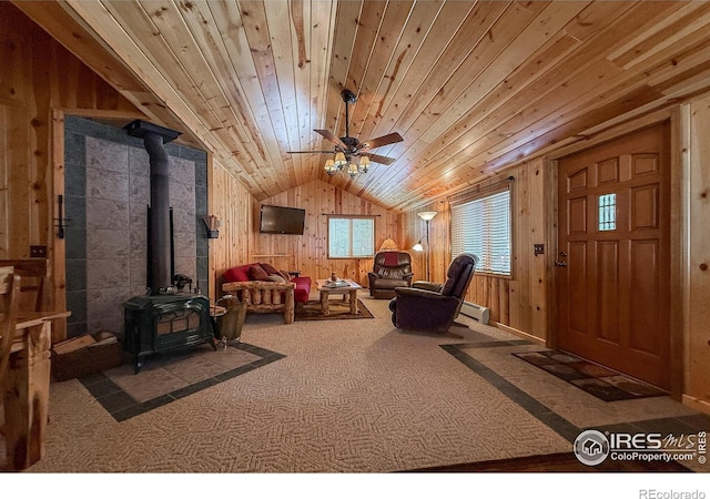 6 Norske Trl, Allenspark, CO 80510 - living area featuring a wood stove, carpet flooring, a ceiling fan, wooden walls, and vaulted ceiling