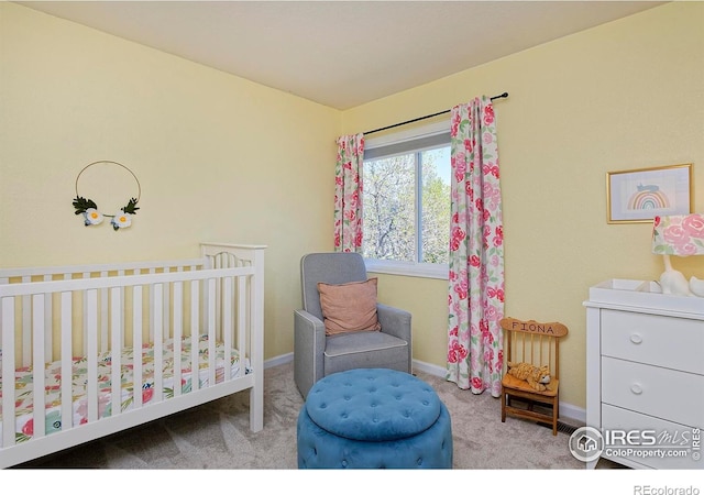 bedroom featuring carpet flooring, a nursery area, and baseboards