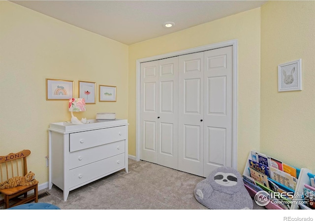 bedroom with light carpet, a closet, and baseboards