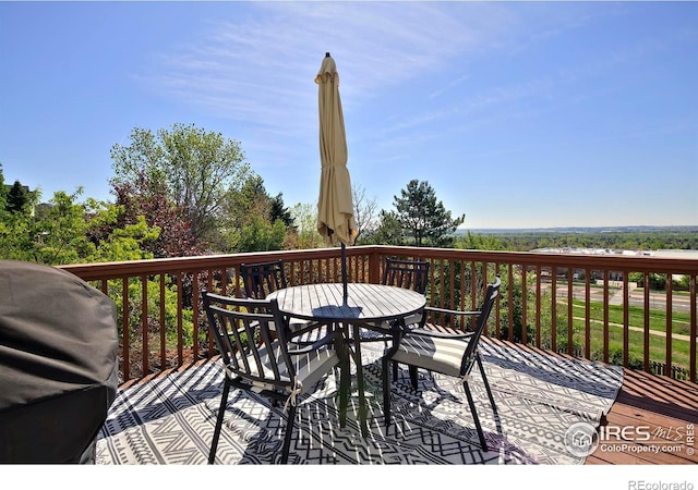wooden terrace with grilling area and outdoor dining area